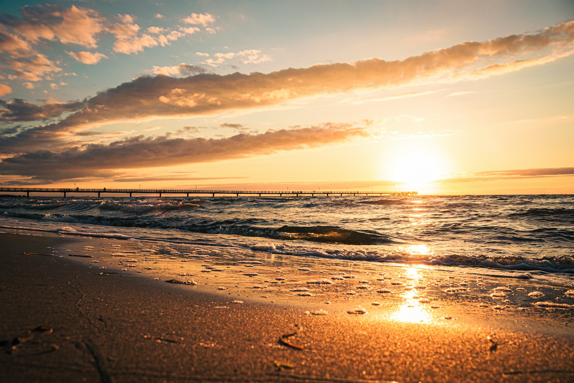 sea waves crashing on shore during sunset